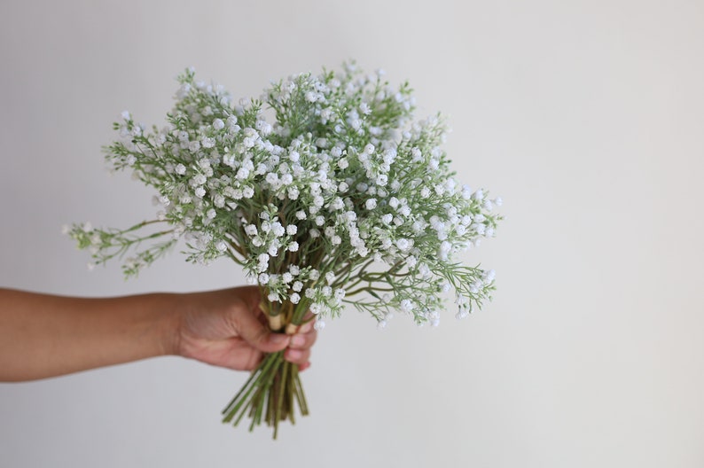 Op de afbeelding: Een boeket witte baby's breath bloemen met groene stelen.