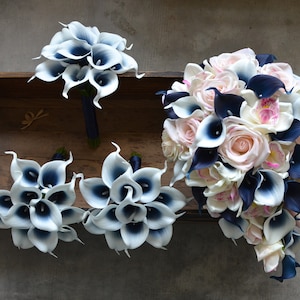 May include: A set of four bridal bouquets featuring white calla lilies with navy blue centers. The largest bouquet also includes pink roses and white orchids.