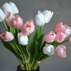 May include: A bouquet of pink and white artificial tulips with green stems and leaves.