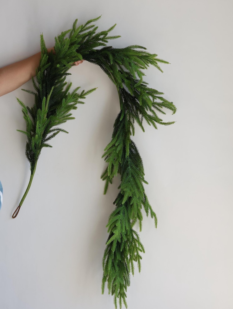 May include: A long, green artificial garland made of pine needles. The garland is flexible and can be shaped into a variety of designs.