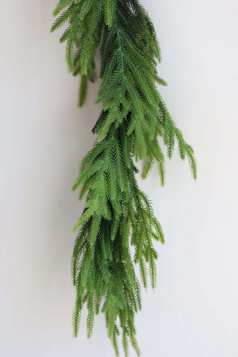 May include: A long, green garland of artificial pine branches, ideal for adding a touch of greenery to your home decor.