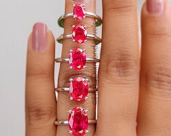 Puede incluir: Un conjunto de siete anillos de rubí ovalados de diferentes tamaños, mostrados en una mano.
