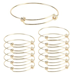 May include: A set of ten gold-toned expandable bangle bracelets. The bracelets are made of metal and have a simple, elegant design.