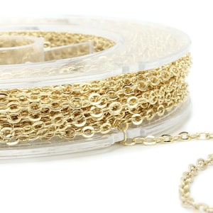 Könnte beinhalten: Eine Spule mit goldfarbener Kette, die um eine transparente Kunststoffspule gewickelt ist. Die Kette ist in einem zarten, feinmaschigen Stil.