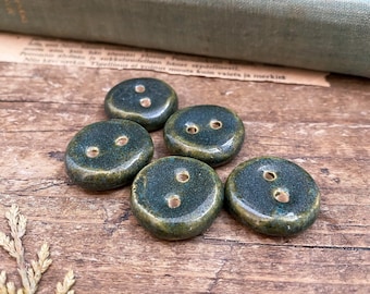 May include: Five green ceramic buttons with two holes each. The buttons have a speckled, uneven texture.