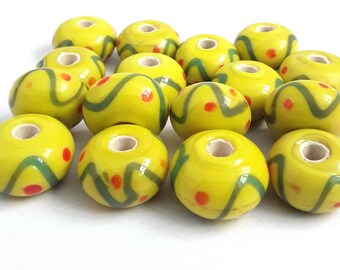 Losse kralen. 16 handgemaakte lampwork ondoorzichtige glaskralen. Afmeting 11 x 18 mm.