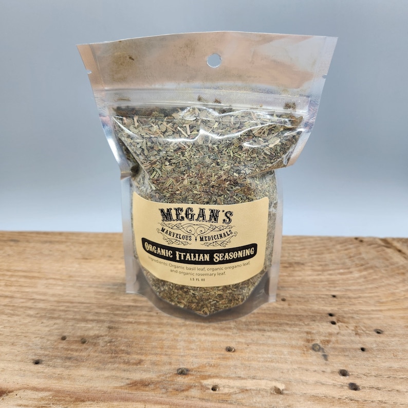A clear resealable bag filled with dried herbs labeled "MEGAN'S MARVELOUS MEDICINALS ORGANIC ITALIAN SEASONING". The ingredients are listed as "organic basil leaf, organic oregano leaf, and organic rosemary leaf".