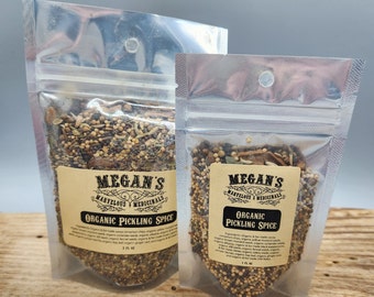 May include: Two clear plastic bags filled with a blend of organic pickling spices. The bags are labeled "Megan's Marvelous Medicinals Organic Pickling Spice" and include a list of ingredients.