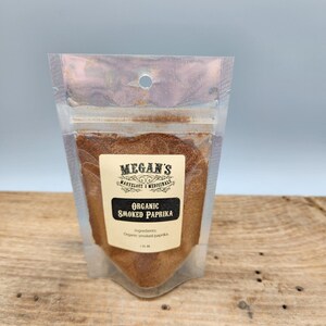 A small clear plastic bag with a brown label that reads "Megan's Marvelous & Medicinals Organic Smoked Paprika" with the ingredients listed as "Organic smoked paprika".
