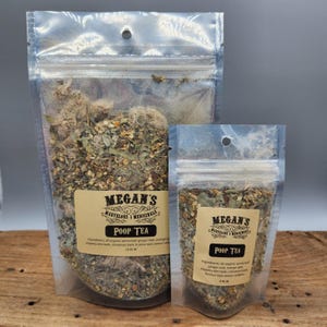 May include: Two clear plastic bags filled with dried herbs and spices. The bags are labeled "Megan's Marvelous Medicinals Poop Tea". The larger bag is 1.5 oz and the smaller bag is 3.5 oz.