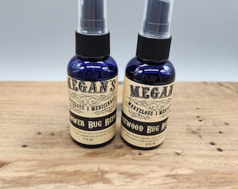 May include: Two 2 fl oz blue glass bottles with black spray tops. The bottles are labeled with a brown paper label that says "Megan's Marvelous Medicinals" and "Flower Bug Repellent" or "Cedarwood Bug Repellent".