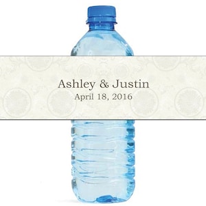 May include: A white water bottle label with a decorative pattern and the text "Ashley & Justin April 18, 2016".