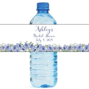May include: Water bottle label with a blue and white floral design. The label says "Ashley's Bridal Shower July 9, 2019".