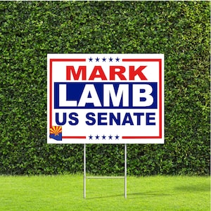 May include: A white yard sign with red, white, and blue text. The sign reads "Mark Lamb US Senate" with stars at the top and bottom.