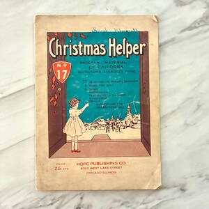 May include: A vintage Christmas Helper No. 17 booklet with a tan cover featuring a child in a white dress looking toward a winter village scene. The text includes Program Material for Children, Recitations, Exercises, Songs, and Hope Publishing Co.