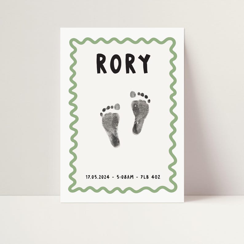 Pu&ograve; includere: Un biglietto bianco con un bordo verde e un motivo ondulato. Il biglietto riporta il nome "RORY" stampato in nero, insieme a due impronte di piedi nere e il testo "17.05.2024 - 5:08AM - 7LB 4OZ".