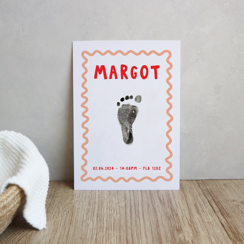 Pu&ograve; includere: Un biglietto bianco con un bordo rosa e una cornice rossa a festoni. Il nome "MARGOT" &egrave; stampato in lettere rosse nella parte superiore. Un'impronta di piede nera si trova al centro del biglietto. La data "02.06.2024", l'ora "14:08PM", il peso "7LB" e la lunghezza "1202" sono stampati in rosso nella parte inferiore.