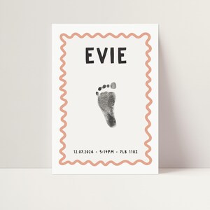 Pu&ograve; includere: Un biglietto bianco con un bordo rosa a festoni. Il biglietto ha un'impronta di piede nera, il nome "EVIE" in testo nero e la data "12.07.2024 - 5:19PM - 7LB 11OZ" in testo nero.