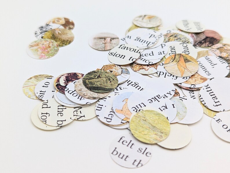 May include: A collection of small, round paper cutouts scattered across a white surface. Each cutout features illustrations and text from a vintage book, with soft colors and a whimsical aesthetic. The cutouts vary in size and are ideal for crafting.