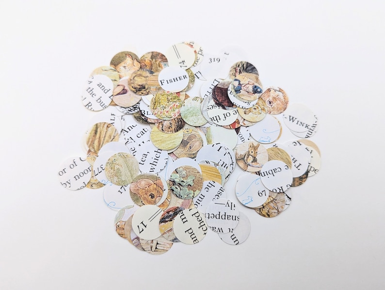 May include: A pile of small, circular paper cutouts. Each cutout features illustrations and text from a vintage book. The images include drawings of animals and people, with text fragments visible. The word "FISHER" is visible on one cutout.