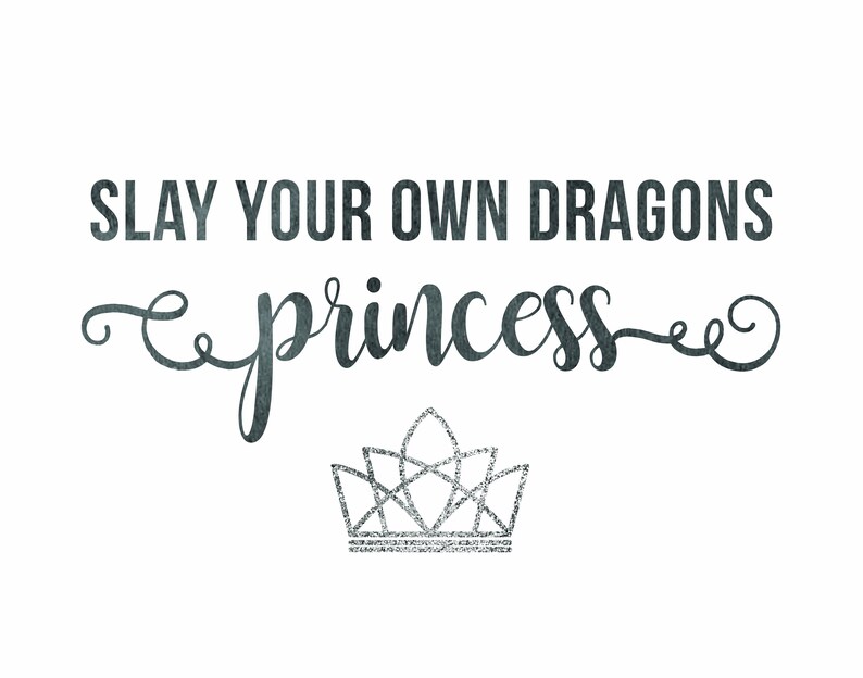 May include: A black and white graphic with the text "SLAY YOUR OWN DRAGONS princess" in a cursive font. A silver glitter crown is below the text.