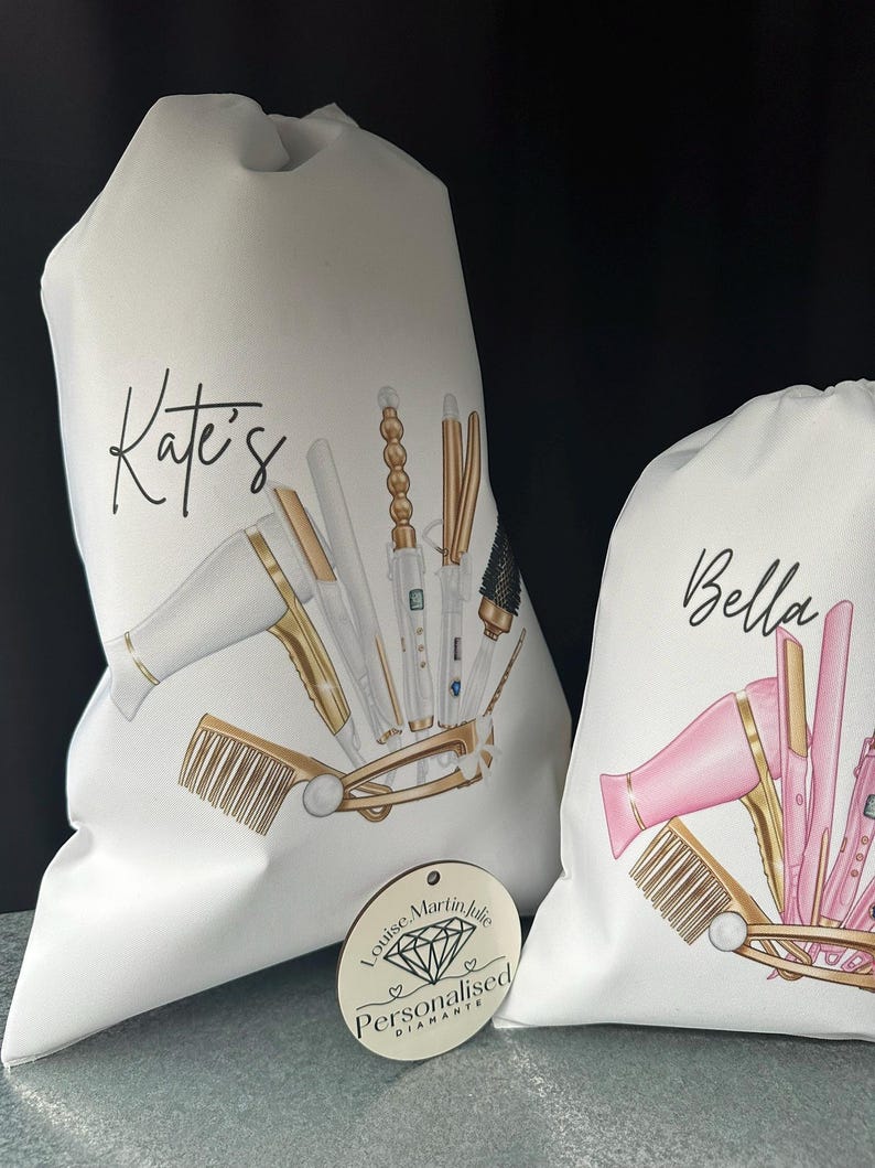 Pode incluir: Duas bolsas de lona brancas com ferramentas de penteado douradas e rosadas impressas nelas. As bolsas s&atilde;o personalizadas com os nomes "Kate's" e "Bella". Uma etiqueta redonda de madeira com o texto "Louise Martin Julie Personalizado Diamante" est&aacute; no canto inferior direito da imagem.