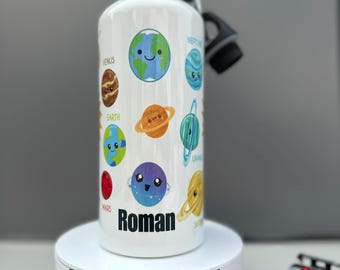 May include: White water bottle with a colorful planets design and the name Roman. The bottle is on a white pedestal with the words "Personalised Diamante" printed on it.