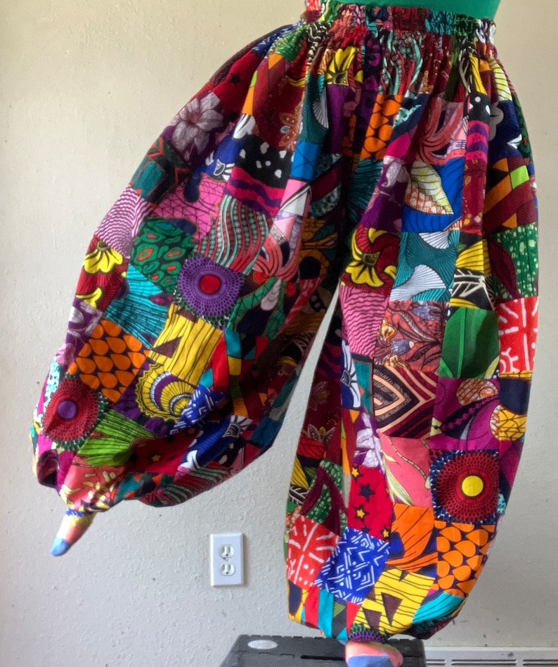 Puede incluir: Pantalones coloridos de patchwork con cintura alta y piernas anchas. Los pantalones est&aacute;n hechos de una variedad de telas en diferentes colores y patrones, incluyendo rojo, amarillo, verde, azul y morado.