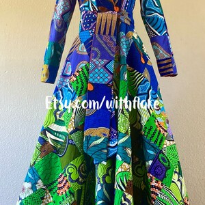 May include: A long-sleeved dress with a patchwork design featuring a variety of colors and patterns, including blue, green, purple, and orange. The dress has a V-neckline and a tie at the waist. The dress is made of fabric with a geometric pattern. The dress is on a mannequin. The text "Etsy.com/withflake" is visible on the dress.