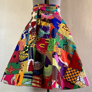 May include: A colorful patchwork skirt with a variety of geometric and floral patterns in shades of red, yellow, blue, green, and black.