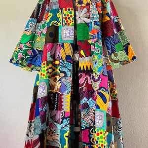 May include: A long, colorful patchwork kimono with a variety of patterns and colors, including red, yellow, green, blue, and purple.