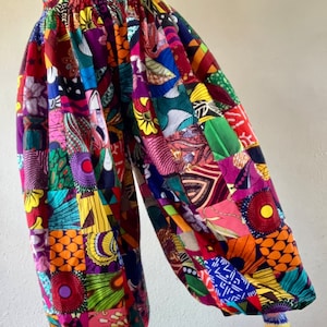 Puede incluir: Pantalones de patchwork coloridos con cintura alta y un corte holgado y fluido. Los pantalones est&aacute;n hechos de una variedad de telas en diferentes colores y patrones, incluyendo rojo, verde, azul, amarillo y morado.