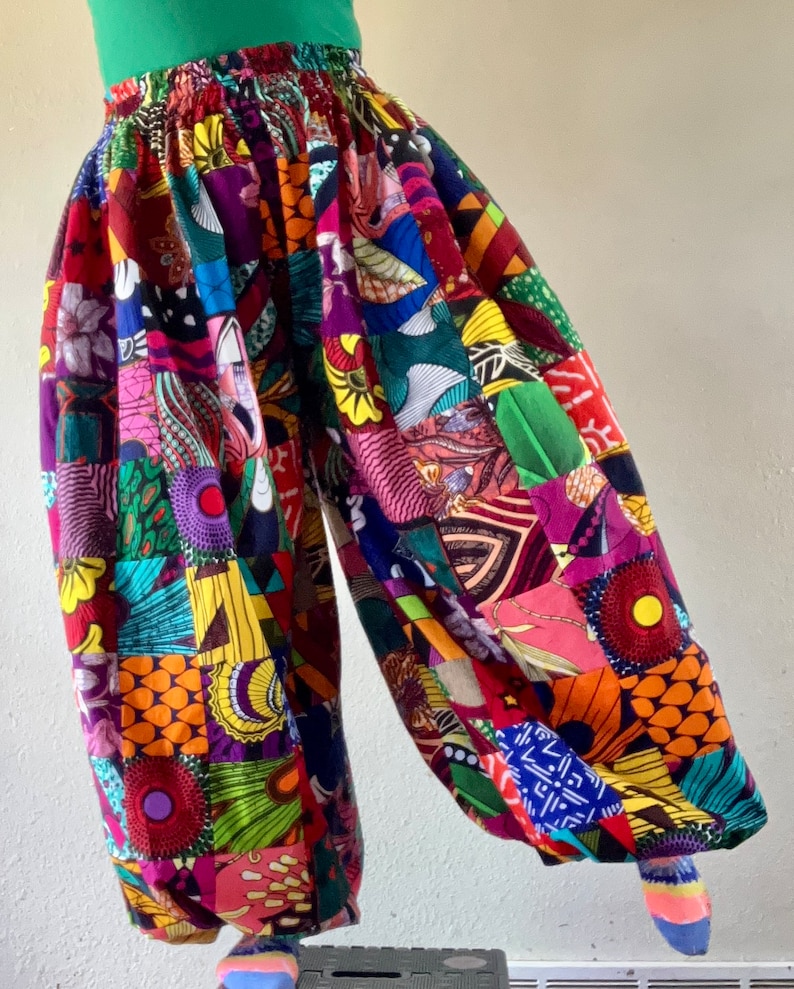 Puede incluir: Pantalones de patchwork coloridos con cintura alta y un corte holgado y fluido. Los pantalones est&aacute;n hechos de una variedad de telas en diferentes colores y patrones, incluyendo rojo, verde, azul, amarillo y morado.