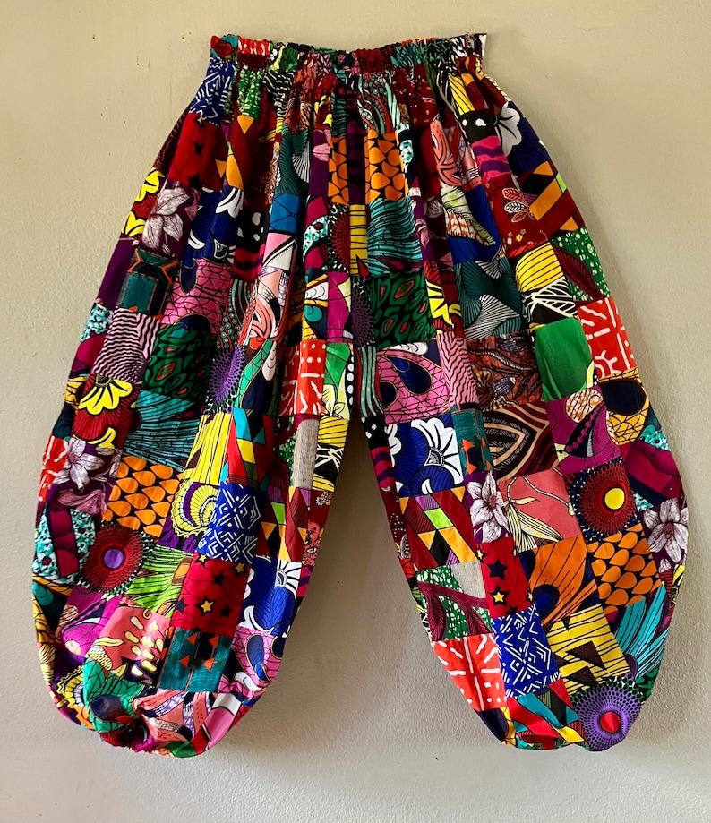 Puede incluir: Pantalones de patchwork coloridos con una cintura el&aacute;stica de talle alto. Los pantalones est&aacute;n hechos de una variedad de telas en colores brillantes, incluyendo rojo, verde, amarillo, azul y morado.