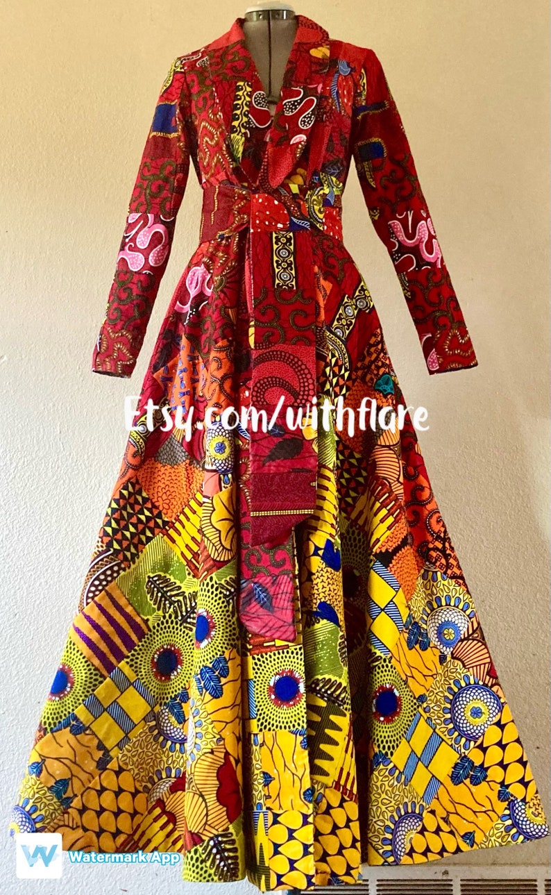 May include: A long-sleeved red dress with a colorful patterned fabric. The dress has a wrap-style bodice and a flared skirt. The fabric features a variety of geometric and floral designs in shades of red, yellow, blue, green, and pink. The dress is tied at the waist with a red sash. The text "Etsy.com/withflare" is visible on the dress.