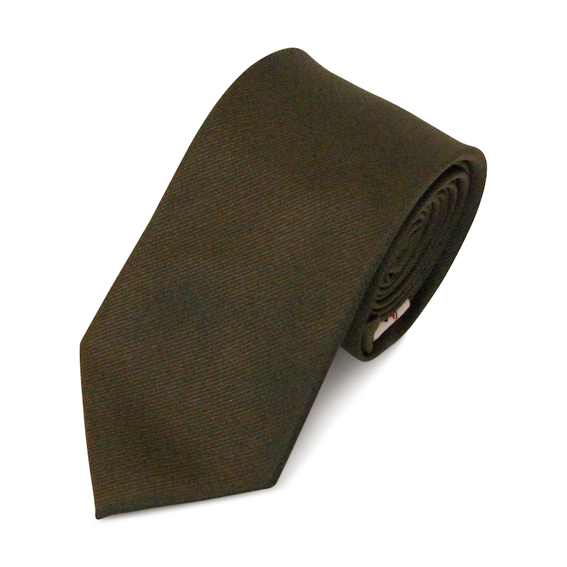 May include: A rolled-up, solid-colored tie in a dark olive green hue. The tie is made of a textured fabric and is angled diagonally across a white background. The tie's end is visible, with a small tag.