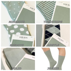 May include: A collection of dusty sage socks featuring various patterns including minidots, thin stripes, big dots, argyle, and solid colours, each paired with a David's Bridal fabric swatch label. One panel shows a pair of solid dusty sage socks.