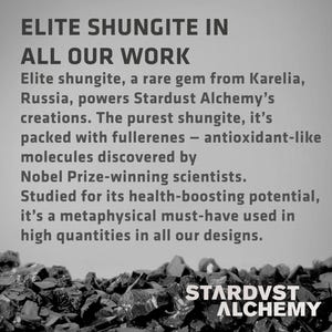 May include: Black and white image of a pile of dark gray rocks with the text "ELITE SHUNGITE IN ALL OUR WORK" and "STARDVST ALCHEMY" at the bottom. The text describes the use of shungite, a rare gem from Karelia, Russia, in the company's products.