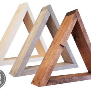 May include: Three wooden triangle shelves in different shades of brown, white, and gray. The shelves are stacked on top of each other, with the largest shelf at the bottom and the smallest shelf at the top. The shelves are made of unfinished wood and have a rustic look. The shelves are labeled "SLIVER WOODWORKING".