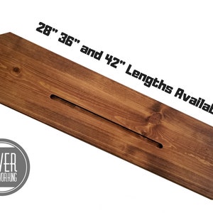 May include: A wooden shelf with a slot cut out, available in 28", 36", and 42" lengths. The shelf is stained a dark brown color. The text "SLIVER WOODWORKING" is on a gray circle.