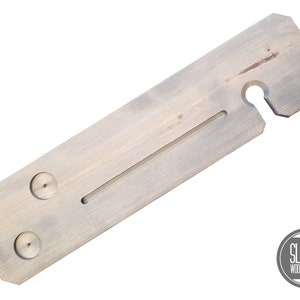 May include: A light gray wooden bath tray with two cup holders, a built-in soap dish, and a hook for hanging a washcloth. The tray is made of natural wood and has a rustic look.