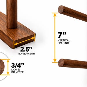 May include: A dark brown wooden wall rack with cylindrical dowels. The board width is 2.5 inches, the dowel diameter is 3/4 inches, and the vertical spacing between the dowels is 7 inches. The rack features visible screw mounting points.