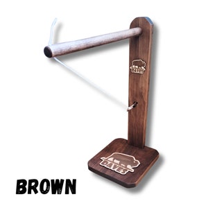 May include: A brown wooden ring toss game with a white string and a buffalo logo on the base. The logo says "Dave's".