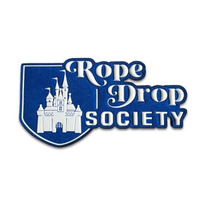 Peut inclure: Logo bleu et blanc avec un château et le texte "Rope Drop Society".