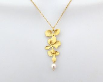 Puede incluir: Un collar de oro con un colgante que presenta tres delicadas flores de orquídea y una sola perla.