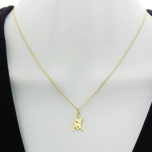 May include: A gold chain necklace with a small gold deer pendant.