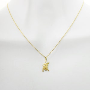 May include: A gold chain necklace with a small deer pendant.