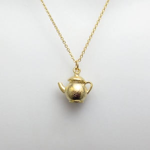 May include: A gold chain necklace with a teapot pendant. The teapot is detailed with a textured surface.