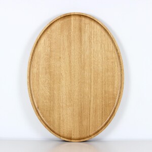 Handcrafted oval serving tray made from premium oak wood, featuring a smooth finish and natural wood grain. Perfect as a large ottoman tray, charcuterie board, or tea serving tray for home decor and entertaining