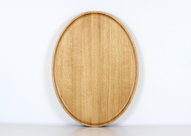 Handcrafted oval serving tray made from premium oak wood, featuring a smooth finish and natural wood grain. Perfect as a large ottoman tray, charcuterie board, or tea serving tray for home decor and entertaining